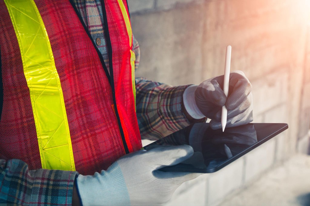 Construction worker using a tablet on site